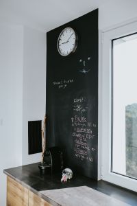 Kaboompics - Kitchen clock with a daily schedule on a blackboard