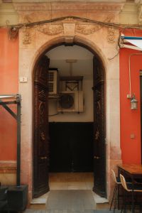 Kaboompics - Vintage Archway Entrance With Ornate Wooden Doors and Air Conditioning Units