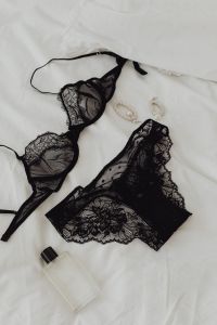 Kaboompics - Black lace underwire bra and panties - perfume - silver earrings - white sheets on the bed