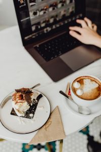 Kaboompics - Working with a laptop, meringue with whipped cream and coffee on white marble