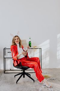 Kaboompics - Woman is sitting in red pants and a white shirt is sitting on a chair with champagne