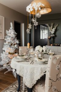 Dining table during Christmas Eve - white Christmas tree, silver-and-white decorations