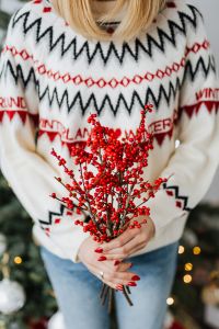 Kaboompics - Woman in a white Christmas sweater holds rowanberry branch