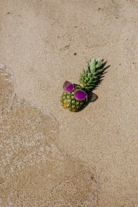 Pineapple with sunglasses on the beach