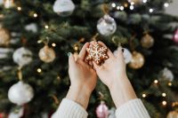 Kaboompics - Woman holds a gingerbread cookie, Christmas tree background