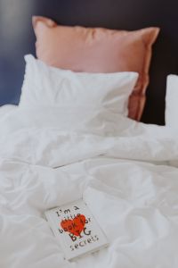 Kaboompics - A diary with red heart on the bed