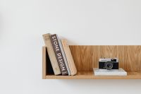 Old analog camera on wooden shelf - books