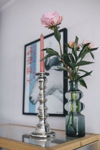 Candle and a flower on a bookcase