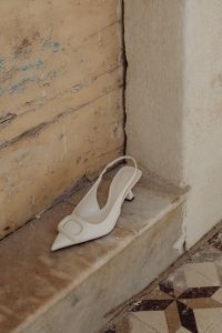 Kaboompics - White high-heeled open-back pumps with front embellishment - Pointed toe - Ankle strap