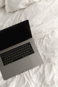 Working with a laptop in bed - white cotton bedding