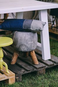 Grey stool with a pillow by a table