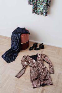 Kaboompics - colored sequin dresses and boots lie on a wooden parquet