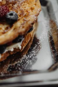 Indulgent Berry-Banana French Toast Feast - Elegant Breakfast with Raspberries and Blueberries