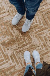Kaboompics - A couple in sports shoes standing on an old brick floor
