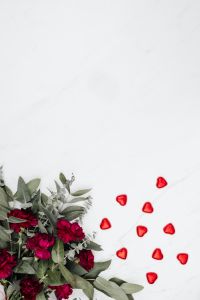 Kaboompics - A bouquet of flowers and a red heart-shaped pralines on white marble