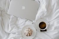 Kaboompics - Macbook, a coffee, a chocolate, a meringue dessert and a notebook in a bed