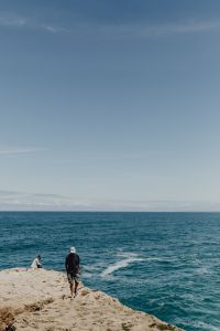 Fishermen with a fishing pole, Cliff on the Western Seaboard of Algarve, Praia da Amoreira, Portugal