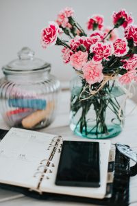 Organizer, mobile phone and lovely pink flowers
