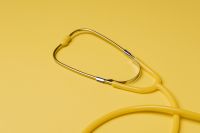 Kaboompics - Yellow stethoscope and pills on yellow background