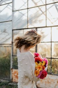 A woman with beautiful colorful dahlia flowers