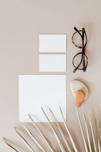 Blank cards & glasses on beige background