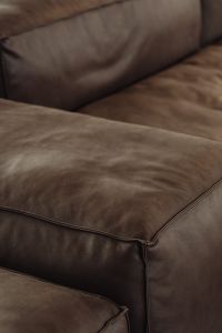 Luxurious brown leather sofa with smooth textured cushions