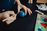 Kaboompics - Woman Painting Blue Easter Eggs