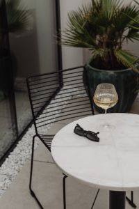 Kaboompics - White Marble Table with a Glass of White Wine and Stylish Sunglasses - Metal Chair