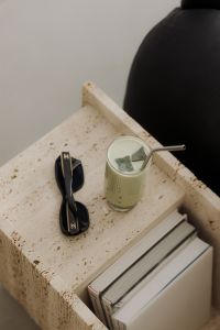 Kaboompics - Matcha Latte on Travertine Table Next to Black Leather Sofa - Japandi Style