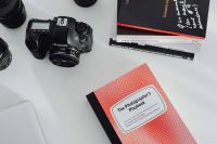 Kaboompics - Photographer's desk - books, DSLR camera and lenses