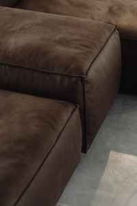 Luxurious brown leather sofa with smooth textured cushions