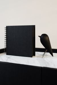 blackbook & wooden bird on marble