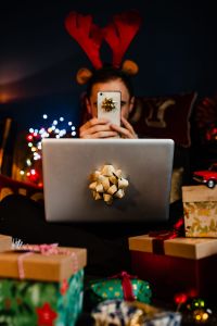 Kaboompics - A handsome man with Christmas presents - using mobile phone & MacBook laptop