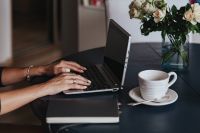 Woman using a laptop by a round breakfast table