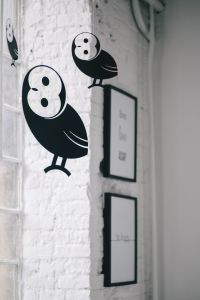 Little black plastic owls hanging from a ceiling