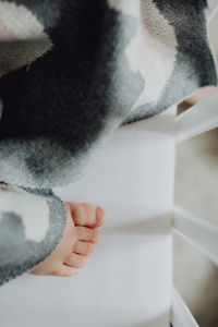 Detail of a newborn baby feet with soft blanket