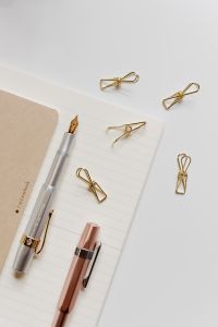Kaboompics - Fountain pens, clips and notebooks on a white desk
