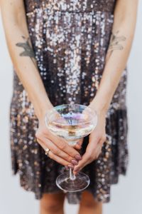 Woman in a Sequin Dress is Holding a Glass of Champagne, White Background