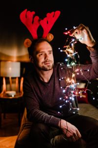 A handsome young man with Christmas tree lamps
