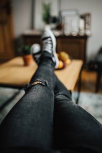 Woman in ripped jeans and black sneakers