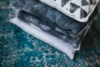 Kaboompics - Stack of pillow of a light blue carpet