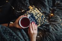 Kaboompics - Young woman at home reading Hygge book and drinking tea
