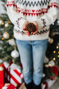 Kaboompics - Woman in a white Christmas sweater holds a cone
