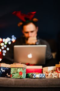 Kaboompics - A handsome man with Christmas presents - using MacBook laptop