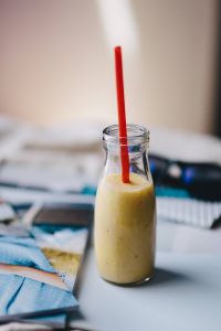 Kaboompics - Healthy shake in a small bottle with a straw and sunglasses