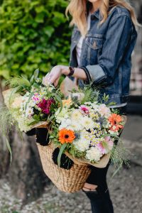 Young woman with basket full of flowers
