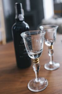Two empty wine glasses with a bottle of wine on a table