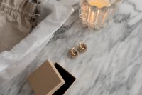Kaboompics - Minimalist UGC-Inspired Jewelry Display on Marble Surface with Elegant Packaging