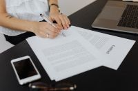 A businesswoman signs a contract