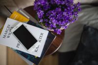 Kaboompics - Books, purple flowers and a white smarphone on a wooden stool by the bed